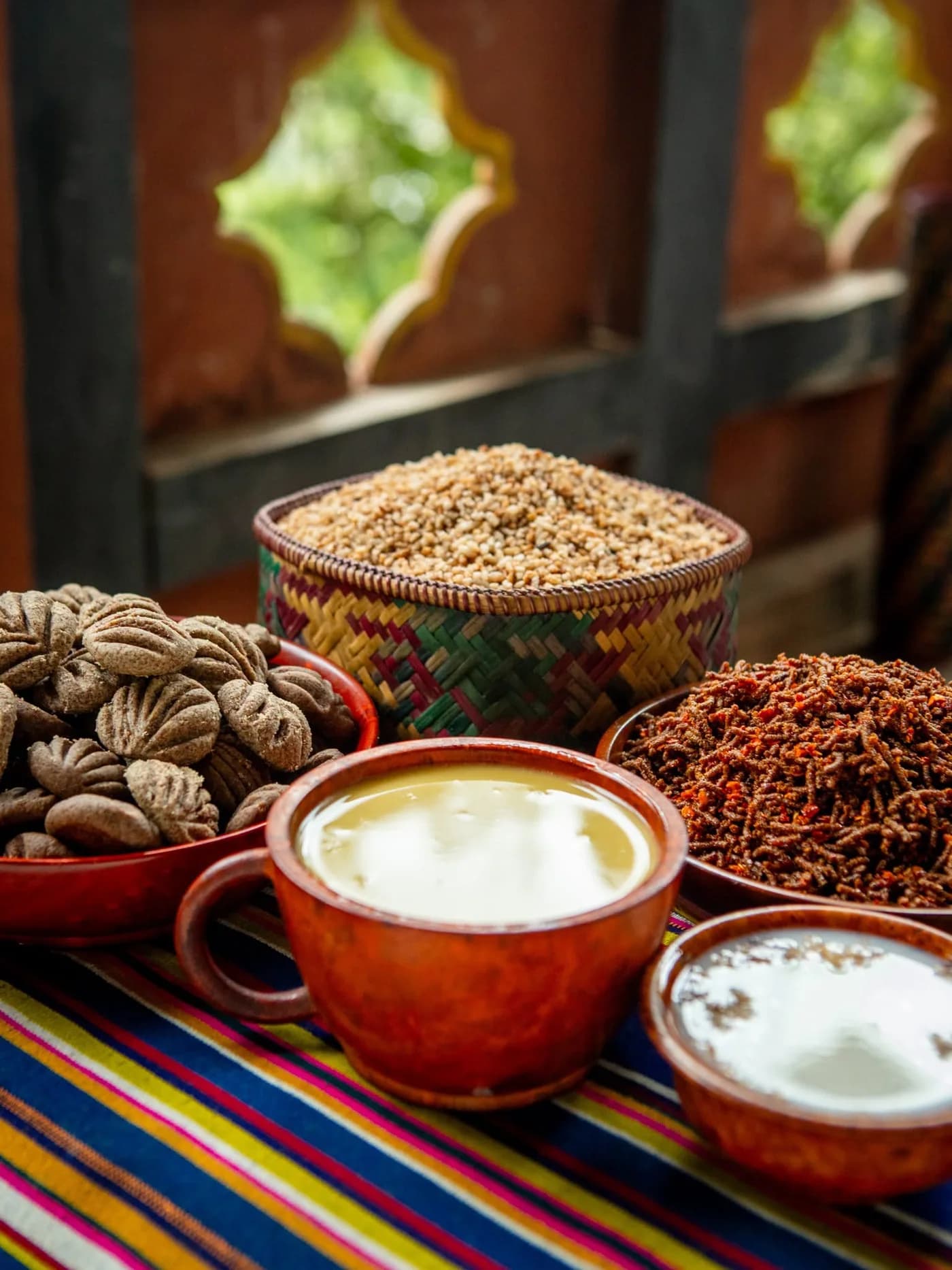 Grains, dried ingredients and cups of tea on a striped cloth